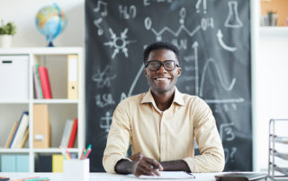 stock photo of teacher at school, blackboard in the background