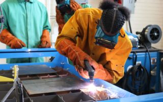 Welding student works in the shop wearing protective glasses