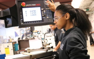 Automated Manufacturing Technology student working on equipment and wearing safety glasses