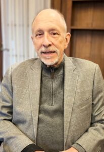 Photo of Interim Executive Director Freeman Burr sitting in office chair